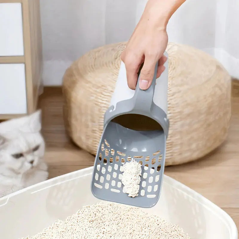 Pelle à Litière Ultime scooping cat litter in a tray.